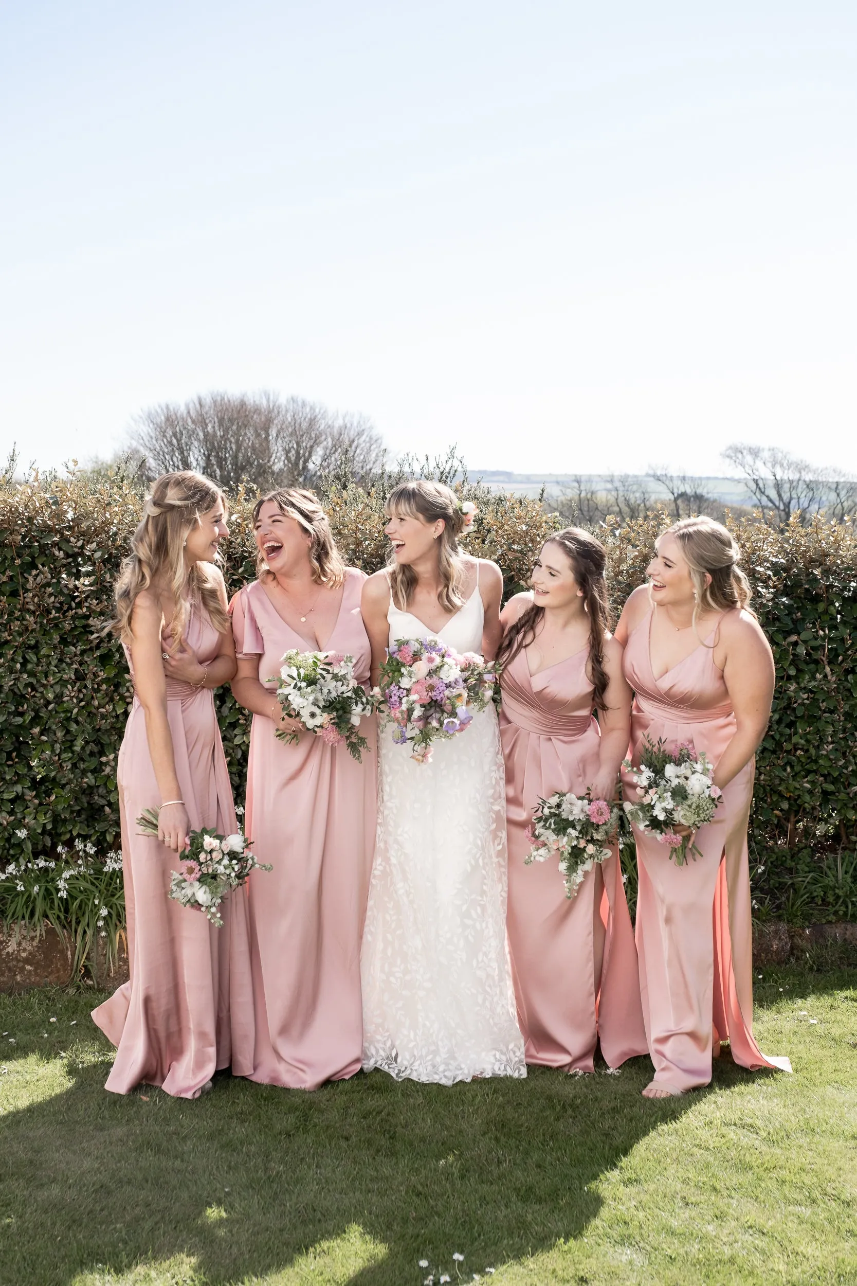 Bridesmaids in dusty pink laughing together