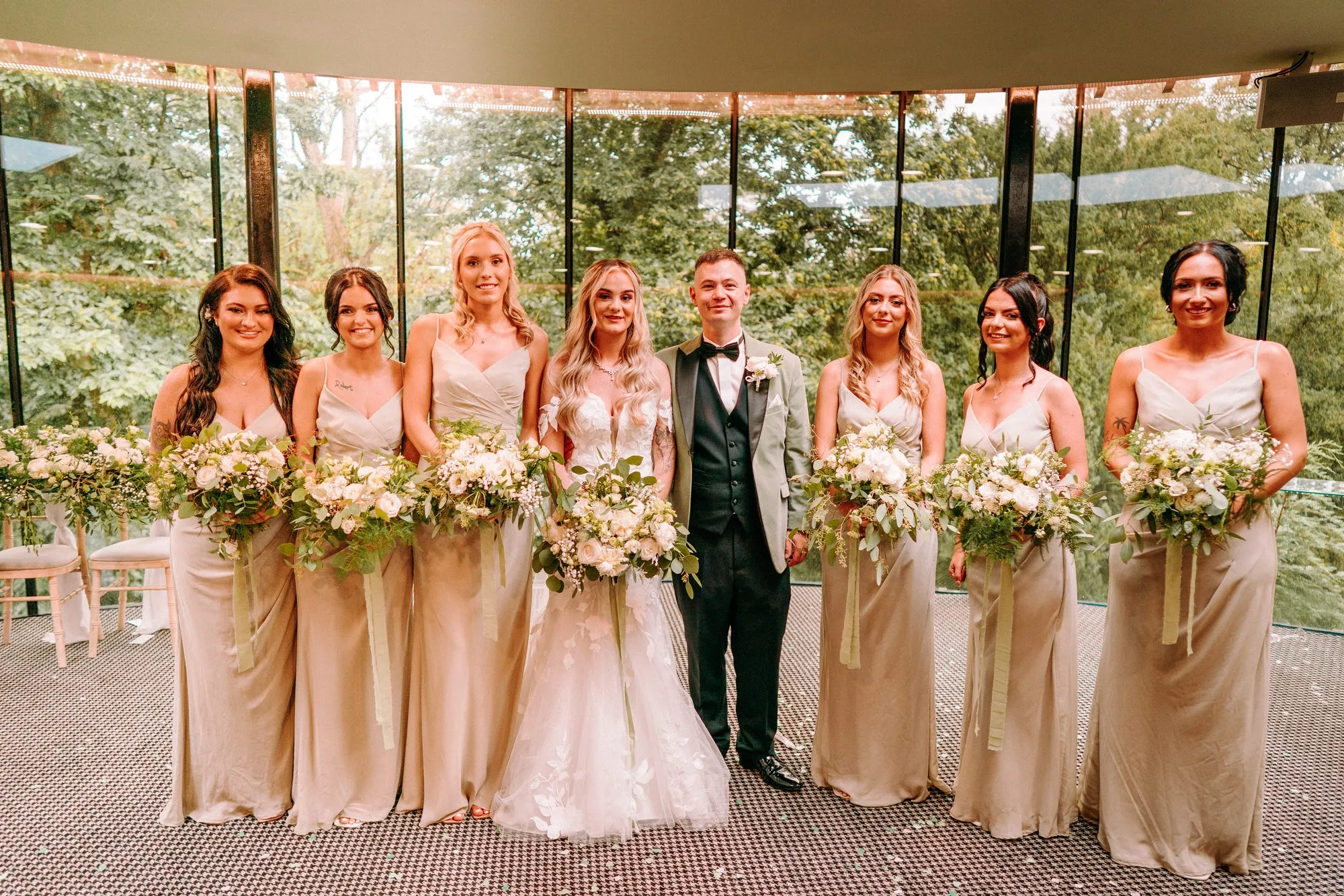 A bridal party beneath a floral canopy