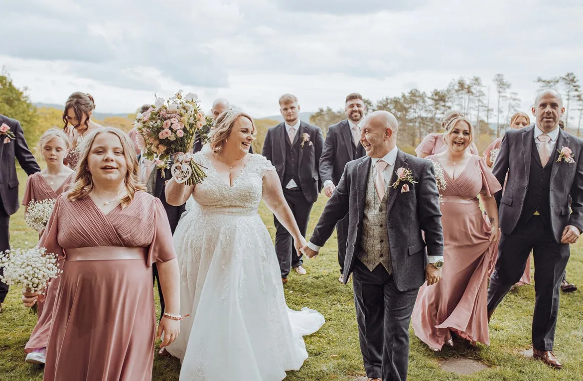 Guests walking to a wedding in dusty pink